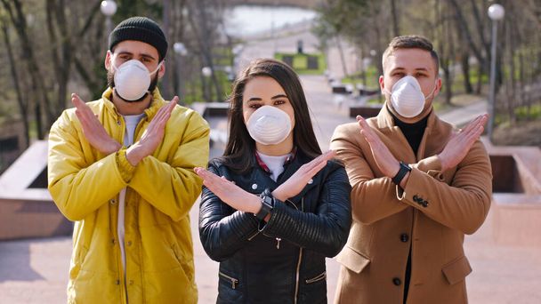 Charismatičtí studenti před kamerou, ukazující zastavení viru Coronavirus, nosí ochrannou masku, když jsou venku u parku. - Fotografie, Obrázek