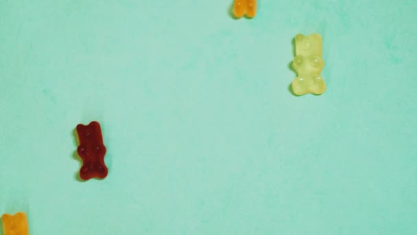 Colorato orsetti gommosi appare su sfondo turchese. Ferma il video. Caramelle di gelatina
  - Filmati, video