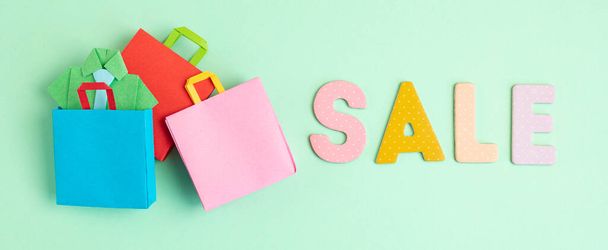 Word Sale και τσάντες για ψώνια χαρτί. Σεσονάλ πώληση, online προσφορές, εκπτώσεις, προώθηση, ψώνια έννοια εθισμού. επίπεδο lay, banner - Φωτογραφία, εικόνα