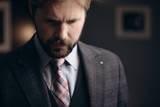 Thoughtful bearded man standing at modern office - Zdjęcie, obraz