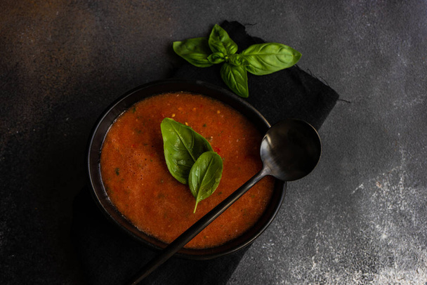 Traditional spanish tomato soup Gazpacho derved in ceranic bowl with fresh basil leaves on stone background with copy space - Valokuva, kuva