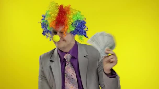 Clown businessman entrepreneur boss in wig with money banknotes at work - Footage, Video