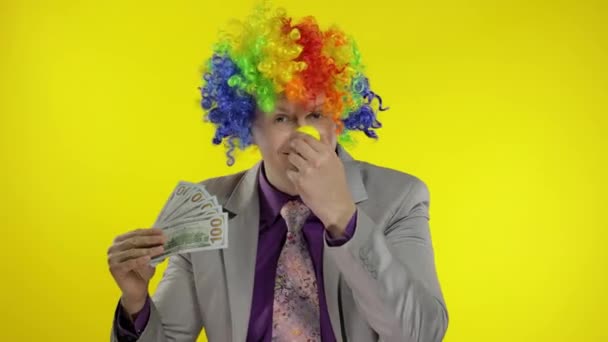 Clown businessman entrepreneur boss in wig waves with money banknotes. Halloween - Footage, Video