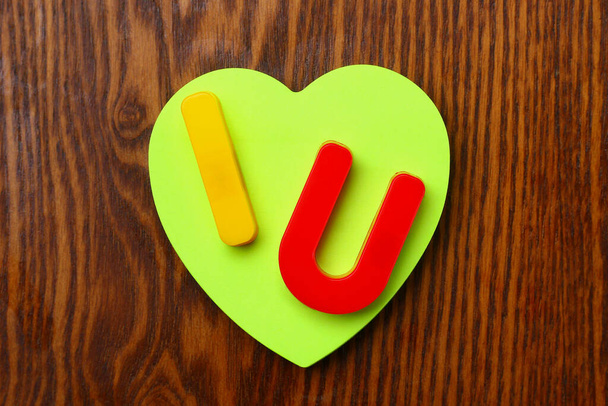 Litery I i U z pustą symboliczną naklejką w kształcie serca. Krótka wiadomość Kocham cię. Kontekst - Zdjęcie, obraz