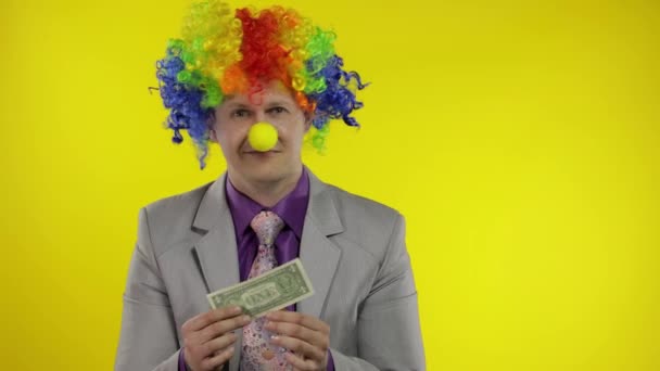 Clown Geschäftsmann Unternehmer mit Perücke hält einen Dollar Geld Einkommen und verliert es - Filmmaterial, Video
