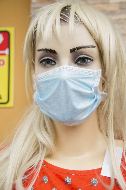 dressed mannequin model in street wearing protective mask during covid-19 pandemic - Photo, Image