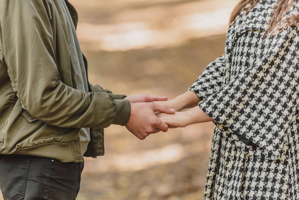 Cropped photo of couple in love holding hands in autumn nature with sunrays everywhere. - Foto, Imagem