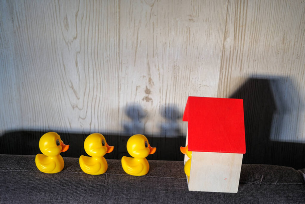Yellow duck and shadow with wooden block house symbol about Stay Home . Covid-19 Coronavirus Concept. - Photo, Image