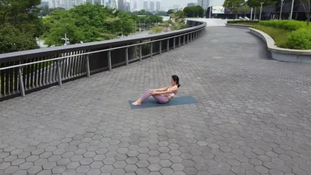 Letecký 4K drone pohled asijské číňanka žena praxe Street jóga jako trend - Záběry, video