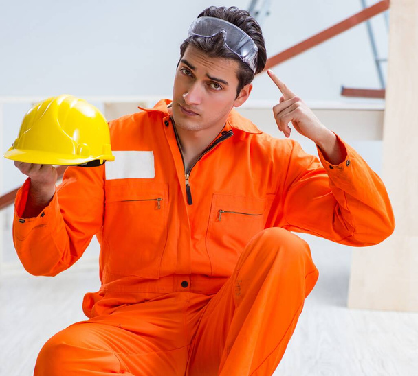 Carpenter wearing yellow hardhat in contractor workshop - Photo, Image