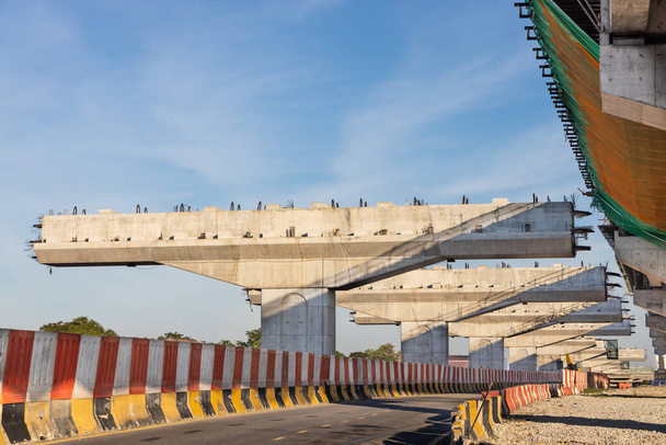 Construction d'un pont-pont routier et d'une infrastructure de transport ferroviaire en cours avec les rayons du soleil matinaux en Malaisie - Photo, image