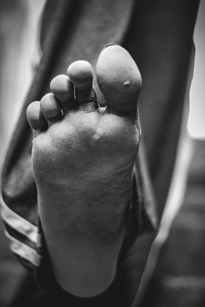 Ανδρικά πόδια πόδια πόδια σε χαμηλή γωνία πλαίσιο. Πονοκέφαλος. Άνδρες κάθονται και δείχνουν επώδυνο πόδι. Έχοντας επώδυνα πόδια και τεντώνοντας τους μυς κόπωση για την ανακούφιση του πόνου. έννοιες υγείας. ανθρώπινο πόδι με δάχτυλα ποδιών. - Φωτογραφία, εικόνα