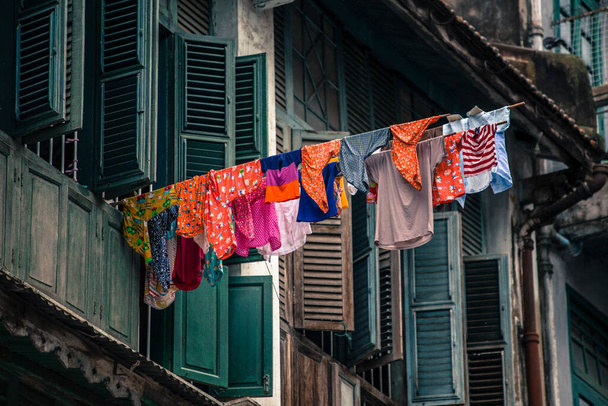 Laundry hanging outside of Old colonial window houten architectuur in Yangon Myanmar Birma Zuidoost-Azië. - Foto, afbeelding