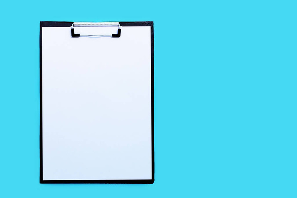 Portapapeles con hoja de papel blanco en blanco sobre fondo azul. Copiar espacio
 - Foto, Imagen