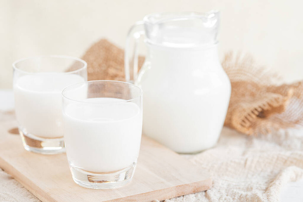 Melk.Melkfles en melkglas op houten tafel.Glazen kan en glas met melk.Gezond eetconcept - Foto, afbeelding