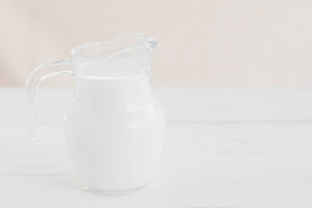 Γαλάκτωμα.Μπουκάλι γάλακτος και ποτήρι γάλακτος σε ξύλινο τραπέζι.Γυάλινη κανάτα και ποτήρι με γάλα.Υγιεινή διατροφική έννοια - Φωτογραφία, εικόνα