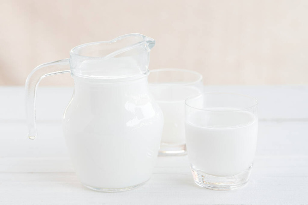 Tej tejesüveg.Tejesüveg és tejes üveg a fa asztalon.Üvegkancsó és üveg tejjel. - Fotó, kép