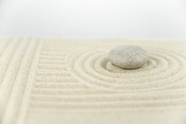 Дзен-сад. Пирамиды белого и серого дзен-камней на белом песке с абстрактными волновыми рисунками. Концепция гармонии, баланса и медитации, спа, массажа, отдыха. - Фото, изображение