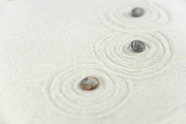 Ogród Zen. Piramidy białe i szare kamienie zen na białym piasku z abstrakcyjnymi rysunkami fal. Koncepcja harmonii, równowagi i medytacji, spa, masaże, relaks. - Zdjęcie, obraz