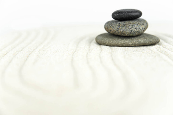 Zen garden. Pyramids of white and gray zen stones on the white sand with abstract wave drawings. Concept of harmony, balance and meditation, spa, massage, relax. - Photo, Image