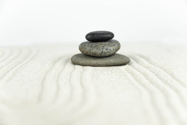 Jardín Zen. Pirámides de piedras zen blancas y grises sobre la arena blanca con dibujos de ondas abstractas. Concepto de armonía, equilibrio y meditación, spa, masaje, relax
. - Foto, Imagen