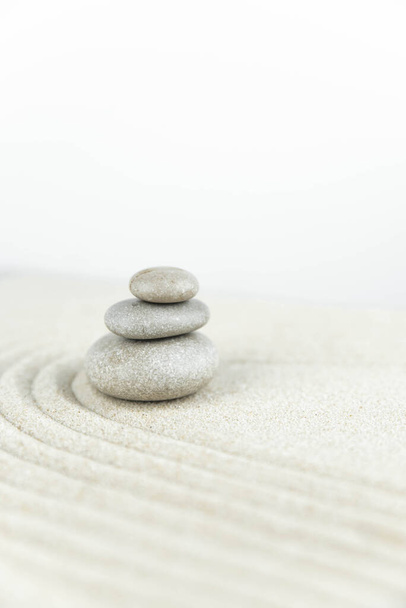 Jardim zen. Pirâmides de pedras zen brancas e cinzentas na areia branca com desenhos de ondas abstratas. Conceito de harmonia, equilíbrio e meditação, spa, massagem, relaxar
. - Foto, Imagem