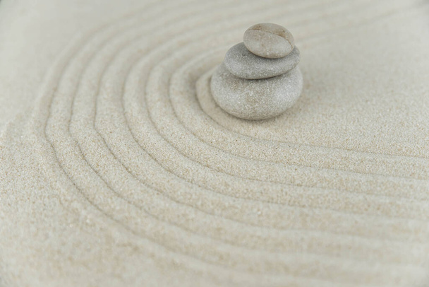 Zen garden. Pyramids of white and gray zen stones on the white sand with abstract wave drawings. Concept of harmony, balance and meditation, spa, massage, relax. - Zdjęcie, obraz