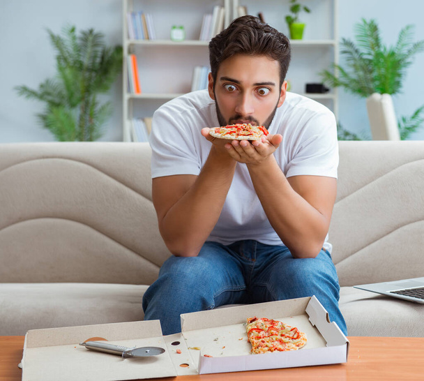 Man eating pizza having a takeaway at home relaxing resting - Φωτογραφία, εικόνα