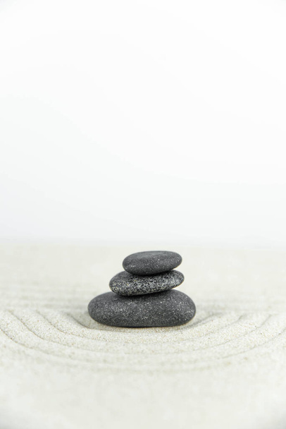 Zen garden. Pyramids of white and gray zen stones on the white sand with abstract wave drawings. Concept of harmony, balance and meditation, spa, massage, relax. - Photo, Image