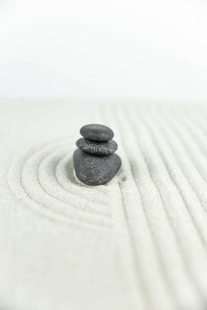 Zenová zahrada. Pyramidy z bílých a šedých zenových kamenů na bílém písku s abstraktními vlnovými kresbami. Koncept harmonie, rovnováhy a meditace, lázně, masáže, relax. - Fotografie, Obrázek