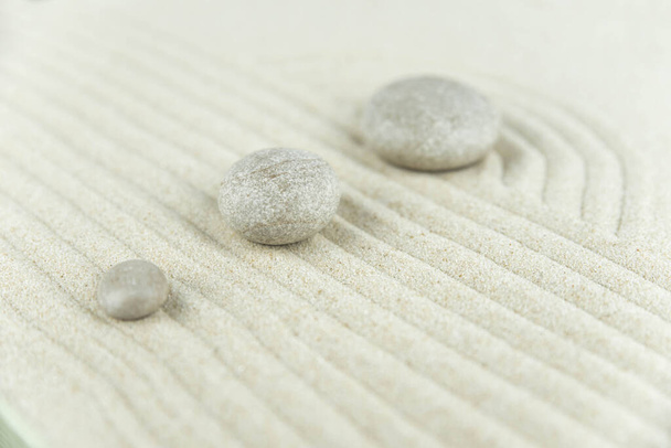Zen puutarha. Pyramidit valkoinen ja harmaa zen kiviä valkoisella hiekalla abstrakti aalto piirustuksia. Käsite harmonia, tasapaino ja meditaatio, kylpylä, hieronta, rentoutua. - Valokuva, kuva