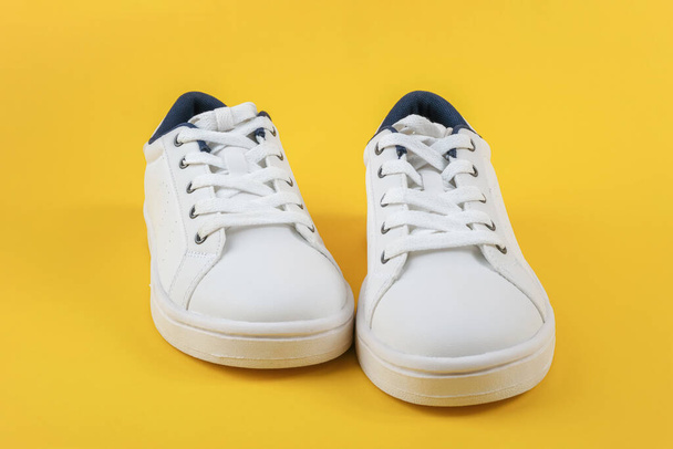 White sports shoes, sneakers with shoelaces on a yellow background. Sport lifestyle concept Top view Flat lay Copy space. - Фото, зображення