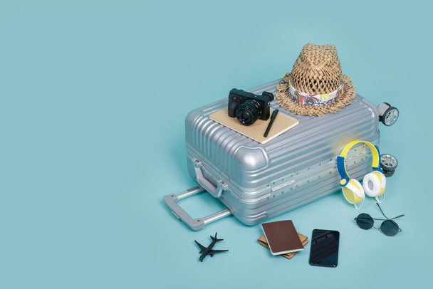 Bagages de voyage avec passeport, appareil photo, chapeau, portefeuille, jouet d'avion et smartphone isolés sur fond bleu avec espace de copie, arrière-plan concept de voyage
 - Photo, image