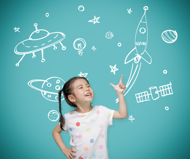 宇宙飛行士と宇宙ロケットを想像して黒板を指差すアジアの子供の女の子、子供の頃のコンセプトの創造と夢 - 写真・画像