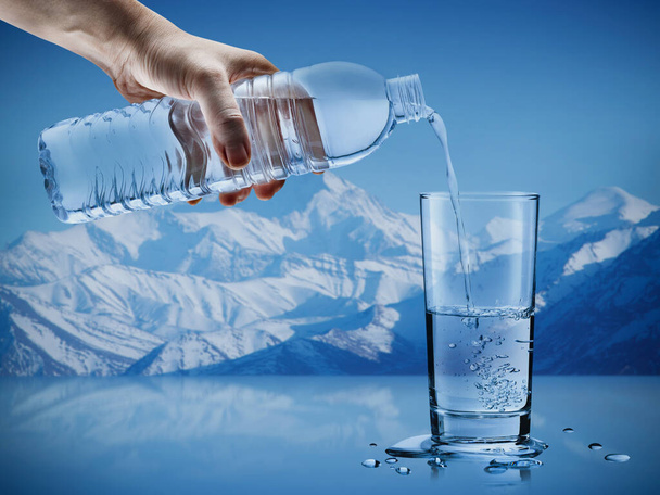 氷山の背景の水滴とガラスにボトルからミネラルウォーターを注ぐ手,ヘルスケアと美しさの水分補給の概念 - 写真・画像