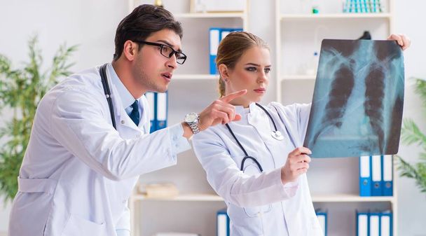 Dos médicos examinando imágenes de rayos X del paciente para su diagnóstico - Foto, imagen