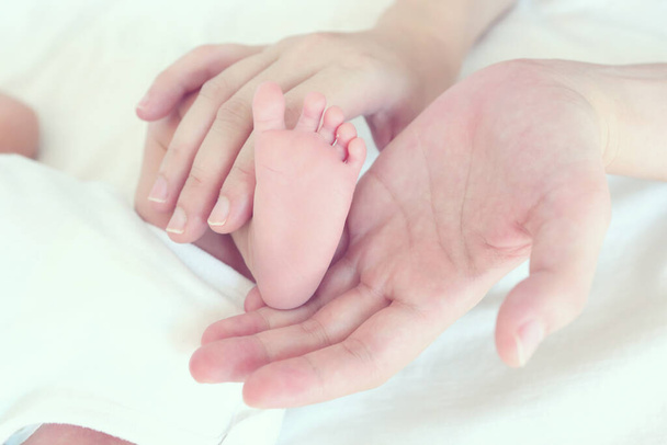 Měkké zaostření a rozmazání dětských nohou v ruce maminka, zdravotní péče a nové rodinné koncepce - Fotografie, Obrázek