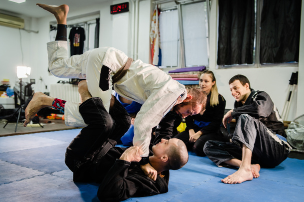 Brezilyalı Jiu JItsu BJJ profesörü gardiyan pozisyonundan öğrencilerine dövüş sanatları akademisinde eğitim dersi veriyor. - Fotoğraf, Görsel