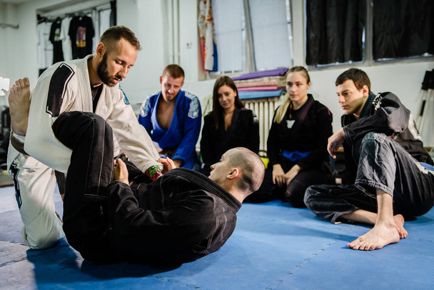 Brazilian Jiu jitsu bjj black belt teaching class or private lessons to his students at the academy martial arts ground fight - Photo, Image