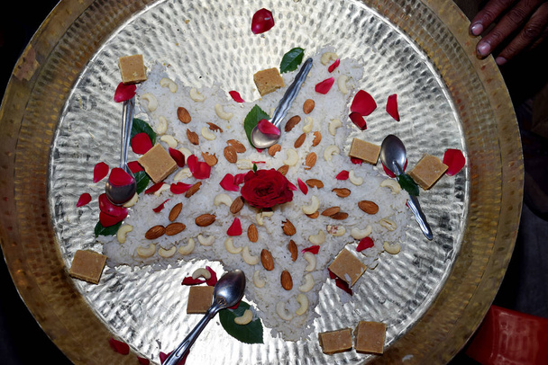 Beau gâteau en riz coloré, décoré avec des fruits secs et des bonbons dans une assiette en laiton
 - Photo, image