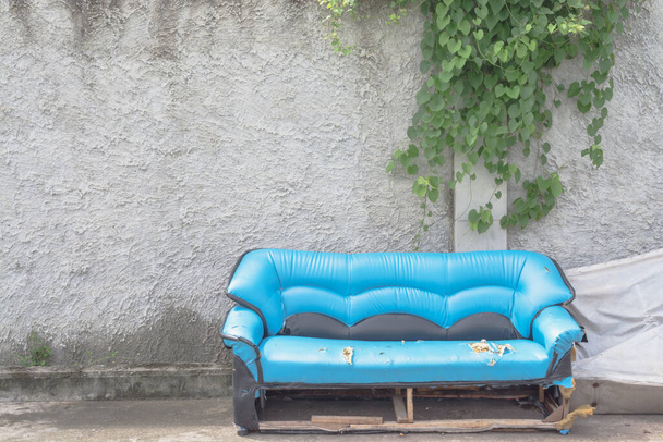 Παλιός καναπές με τοίχο έχει αμπέλι κρέμεται - Φωτογραφία, εικόνα