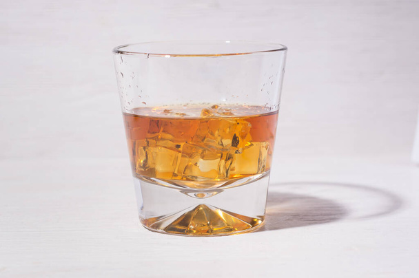 Old and tasty cognac with ice in a conical glass beaker - Фото, зображення