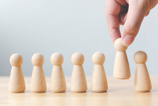 Human resource, Talent management, Recruitment employee, Successful business team leader concept. Hand chooses a wooden people standing out from the crowd. - Photo, Image
