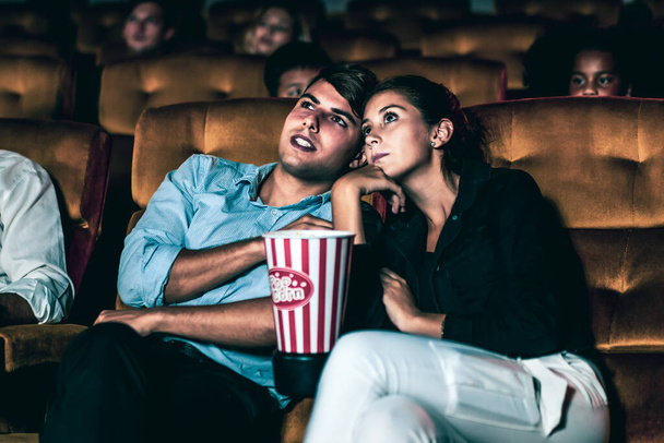 A couple of lovers watching movie shock and eyes close in the movie theater cinema. - Photo, Image