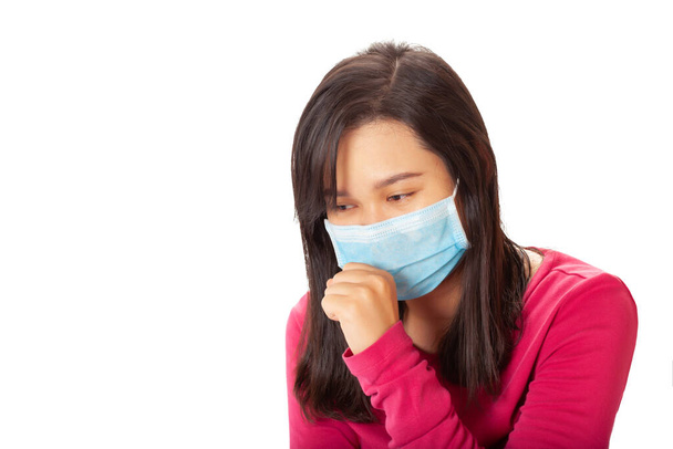Jovem mulher asiática vestindo uma máscara de proteção anti vírus para evitar que outros do vírus corona ou COVID-19 e ela está sofá isolado no fundo branco
 - Foto, Imagem