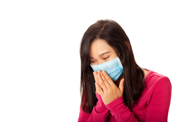 Mujer asiática joven que lleva una máscara de protección contra el virus para evitar que otros del virus de la corona o COVID-19 y ella está estornudando aislado sobre fondo blanco
 - Foto, imagen
