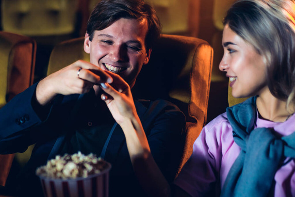Caucasian lover enjoying to watch movie and eating popcorn together in the cinema - Photo, Image