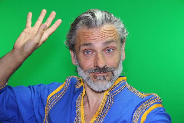 mature man in traditional costume dancing over green screen - Photo, Image