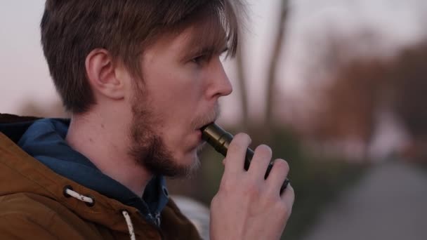 Portrait of a young man on the road Smoking electronic cigarettes - Filmati, video