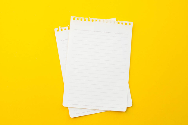 empty paper of notebook on yellow background with school concept. - Photo, Image